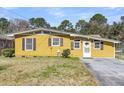 Charming yellow home exterior with a well-maintained lawn and classic shutters at 1442 N Sherwood Drive Dr, Charleston, SC 29407