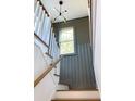 Staircase with a wooden banister and stylish gray wood paneling at 1468 Alligator Creek Ct, Awendaw, SC 29429