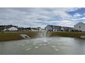 Scenic pond with a fountain and newly built homes in the background, creating a peaceful community ambiance at 183 Carolina Groves Blvd, Moncks Corner, SC 29461