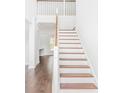 Elegant staircase with wooden steps and white railings leading to the second floor at 201 Seele St, Lincolnville, SC 29485