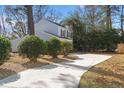 Long concrete driveway leading to a two-story home with lush green landscaping at 2028 Wild Flower Lane, Charleston, SC 29414