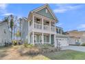 Stylish two-story home with a spacious second-story balcony, porch, and well-manicured lawn at 207 Calm Water Way, Summerville, SC 29486