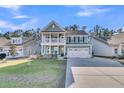 Lovely two-story home with a charming porch, inviting second-story balcony, and a two-car garage at 207 Calm Water Way, Summerville, SC 29486