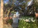 Beautiful home with lush landscaping, a white fence, and steps leading to the front entrance at 24 Commons Ct, Isle of Palms, SC 29451