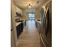 Galley kitchen with stainless steel appliances, modern lighting, and a view to a dining area with lots of light at 291 Sea Cloud Cir # 291, Edisto Island, SC 29438