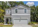 Charming two-story home with a neatly maintained lawn and attached two car garage in a suburban neighborhood at 303 Pine Crest View Dr, Summerville, SC 29486