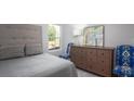 Cozy bedroom with a patterned headboard, gray bedding, and colorful accent chairs at 310 Tiliwa St, Summerville, SC 29486