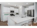 Bright kitchen with stainless steel appliances, white cabinets, quartz countertops, and bar stool seating at the island at 564 Richfield Way, Summerville, SC 29486