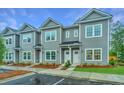 Gray two-story townhomes featuring manicured front lawns, symmetrical facades, and white doors and window trim at 704 Twin Rivers Dr # 44, Wando, SC 29492