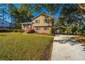 Charming two-story home with a brick facade, manicured lawn, and covered parking at 7639 Northhaven Dr, North Charleston, SC 29420