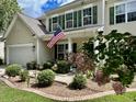 Traditional home featuring manicured front yard, neutral siding, green shutters, and a welcoming front porch at 9656 Pebble Creek Blvd, Summerville, SC 29485
