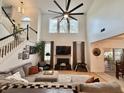 Spacious living room with high ceilings, large windows, a modern fan, fireplace, and comfortable seating area at 9656 Pebble Creek Blvd, Summerville, SC 29485