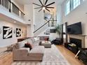 Bright living area features soaring ceilings, a fireplace, hardwood floors and a comfortable sectional couch at 9656 Pebble Creek Blvd, Summerville, SC 29485