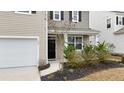 Inviting front door with a well-kept yard and a concrete driveway leading to the garage at 103 Cardinal Flower Ct, Moncks Corner, SC 29461