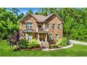 Charming brick two-story home featuring a manicured lawn and lush landscaping at 1208 Red Buckeye Ct, Moncks Corner, SC 29461