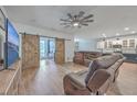Open-concept living room featuring wood floors, a ceiling fan and access to the kitchen at 132 Mcclellan Way, Summerville, SC 29483
