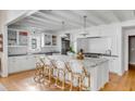 Well-appointed kitchen with white cabinetry, marble island with seating, and stainless steel appliances at 14 Guerard Rd, Charleston, SC 29407