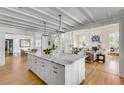 Open concept kitchen featuring a marble island, custom cabinets, stainless appliances, and hardwood floors at 14 Guerard Rd, Charleston, SC 29407