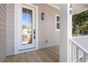 A close-up view of a charming front porch featuring a white door and classic railing at 1439 Periwinkle Dr, Mount Pleasant, SC 29466