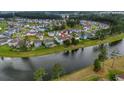 Beautiful aerial view of a home in a lakeside community surrounded by colorful homes and lush green trees at 149 Calm Water Way, Summerville, SC 29486