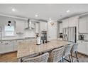 A spacious kitchen featuring white cabinets, stainless appliances, a large center island, and granite countertops at 149 Calm Water Way, Summerville, SC 29486