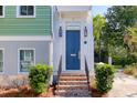 Close-up of the home's entry, showing the brick steps and a stylish blue front door with sidelights at 17 Trumbo St, Charleston, SC 29401