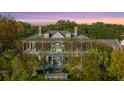Stately home with a metal roof and multiple balconies, surrounded by lush trees at 186 N Shelmore Blvd, Mount Pleasant, SC 29464
