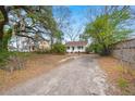 Charming home featuring a long gravel driveway and an inviting front porch at 209 E 1St N St, Summerville, SC 29483