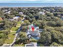 Aerial view of coastal neighborhood featuring stunning home with a private pool and ocean in the distance at 27 22Nd Ave, Isle of Palms, SC 29451