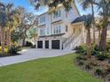 Beautiful two-story home with a three-car garage, surrounded by lush landscaping and palm trees at 27 22Nd Ave, Isle of Palms, SC 29451