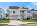 Inviting two-story home with a double front porch, white columns, a well-manicured lawn and a two car garage at 2942 Clearwater Dr, Mount Pleasant, SC 29466