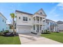Inviting two-story home with a double front porch, white columns, a well-manicured lawn and a two car garage at 2942 Clearwater Dr, Mount Pleasant, SC 29466