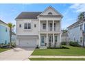 Inviting two-story home with a double front porch, white columns, a well-manicured lawn and a two car garage at 2942 Clearwater Dr, Mount Pleasant, SC 29466