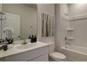 Bright bathroom featuring a shower over tub, white vanity and a large mirror at 305 Tiliwa Street, Summerville, SC 29486