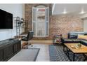 Inviting living room with exposed brick, comfortable seating, a stylish coffee table, and a view of the window at 377 King St # 203, Charleston, SC 29401