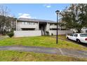 Exterior of condo building with grass area, car parked on side and mature trees at 402 Greencastle Dr, Goose Creek, SC 29445
