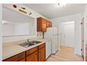 A bright kitchen featuring white appliances, cabinets, and a double sink at 402 Greencastle Dr, Goose Creek, SC 29445