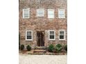 Two story brick home with a weathered door and lush landscaping at 42 1/2 Hasell St, Charleston, SC 29401