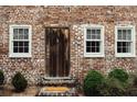 A rustic wooden door with sidelight windows, set in a brick facade at 42 1/2 Hasell St, Charleston, SC 29401