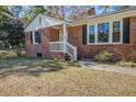 Close up of a brick house with a small front porch and white railing at 425 Ravenwood Rd, Walterboro, SC 29488