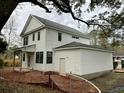 View of the rear of a two-story home with white siding and an attached garage at 5806 Beverly Dr, Hanahan, SC 29410