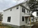 Side view of this new home showing the white siding, black trim, and front porch at 5806 Beverly Dr, Hanahan, SC 29410