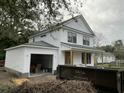 View of the home showing white siding and an attached garage and front porch at 5806 Beverly Dr, Hanahan, SC 29410