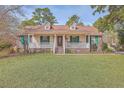 Traditional home boasts a lovely front porch, green shutters, and a manicured front lawn at 634 Lakeside Dr, Moncks Corner, SC 29461