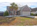 Charming single-story brick home features an attached garage and a well-maintained front yard with a mature palm tree at 7836 Lumberton Rd, North Charleston, SC 29418