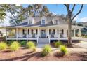 Inviting front porch with classic rocking chairs and a charming entrance, perfect for relaxing outdoors at 1048 Wharf Indigo Pl, Mount Pleasant, SC 29464