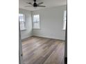Bright bedroom with wood-look floors, three windows and white trim at 1137 Moss Grove Dr Dr, Moncks Corner, SC 29461