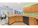 Bright kitchen with wood cabinetry, stainless steel sink, and breakfast bar, seamlessly flowing into the dining area at 1227 Cosmos Rd, Summerville, SC 29483