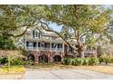 Two-story home with a covered porch, brick foundation, and manicured lawn, perfect for Gathering living at 1429 Burningtree Rd, Charleston, SC 29412