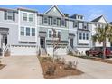 Stylish townhome exterior featuring attached garages and well-maintained landscaping at 1549 Moss Spring Rd, Mount Pleasant, SC 29466